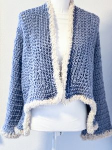 Cardigan asimmetrico blu con bordo panna ad uncinetto
